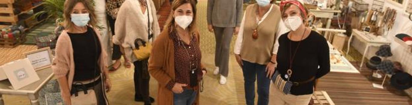 Siete mujeres en el centro comercial posando ante la cámara.